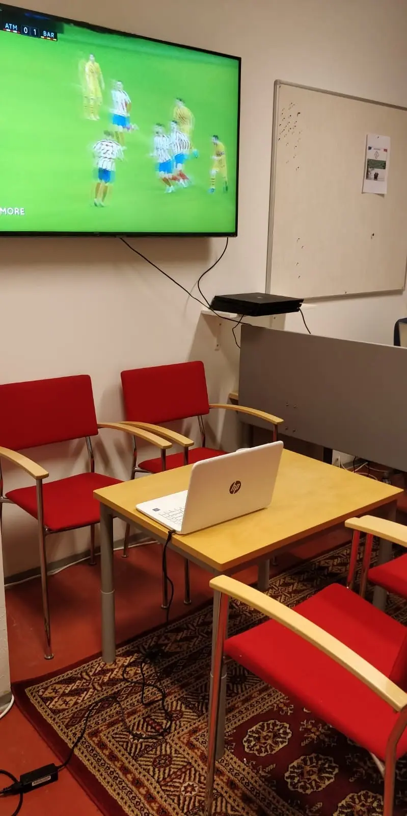 Sisätila, jossa jalkapallo-ottelua näytetään television ruudulla.