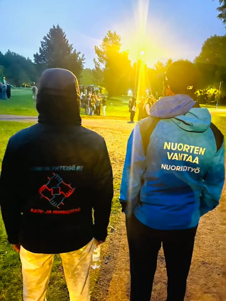 Nuorisotyöntekijät ulkona auringonlaskun aikaan.